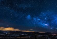 black mountains under the stars at nighttime