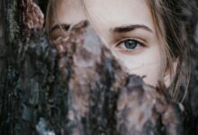 calm woman behind tree bark in park