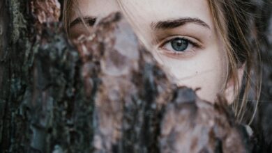 calm woman behind tree bark in park